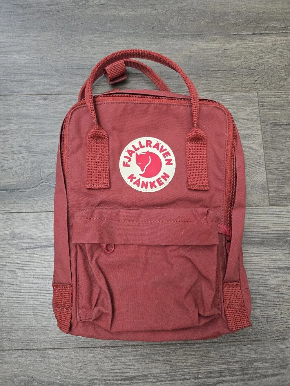 Fjällräven Kånken Mini backpack in a deep orange/red Tragel Vacation School